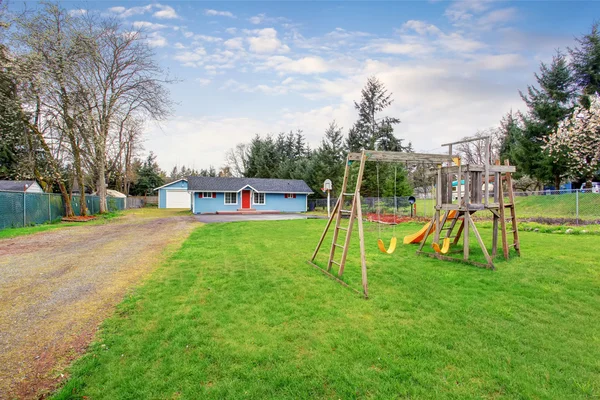 Cour arrière clôturée avec aire de jeux en bois pour les enfants — Photo