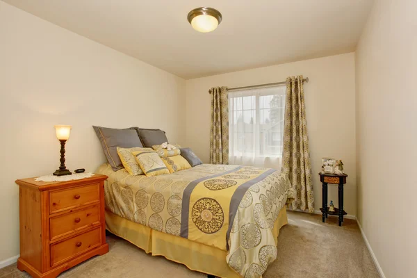 Bella camera da letto interna con biancheria da letto gialla, pavimento in moquette e comodino . — Foto Stock
