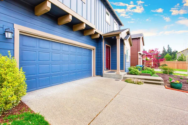 Casa blu esterna. Vista garage e portico con porta d'ingresso rossa . — Foto Stock