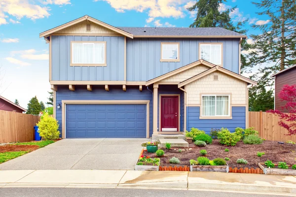 Schöne Bordsteinattraktion von blauem Haus mit Vorgarten und Garage mit Einfahrt — Stockfoto