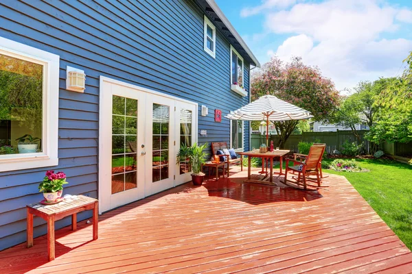 Wooden walkout deck in the backyard garden of blue siding house. — Stok fotoğraf