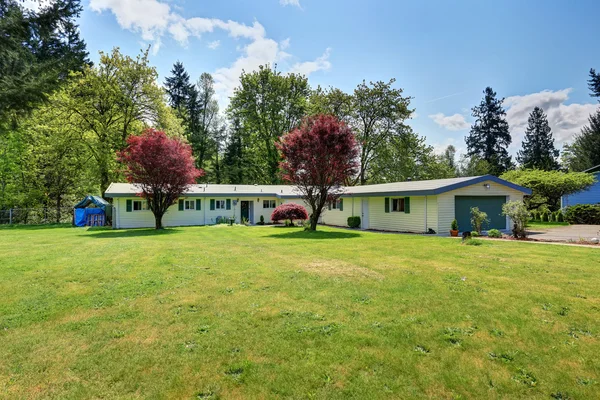 Exterior da casa rambler americano com grama cheia jardim frontal — Fotografia de Stock