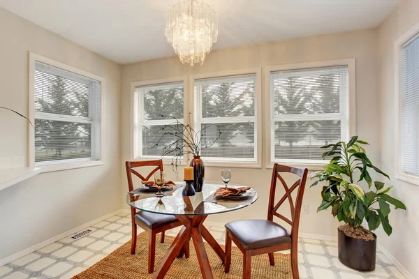 Zona de comedor con mesa de cristal y ventanas alrededor — Foto de Stock