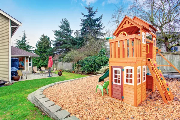 Umzäunter Hinterhof mit Holzspielplatz — Stockfoto