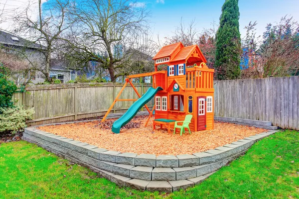 Umzäunter Hinterhof mit Holzspielplatz — Stockfoto