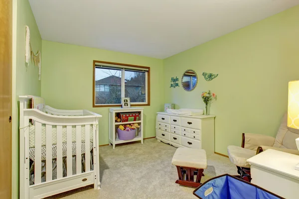 Детская спальня с белой мебелью и зелеными стенами — стоковое фото