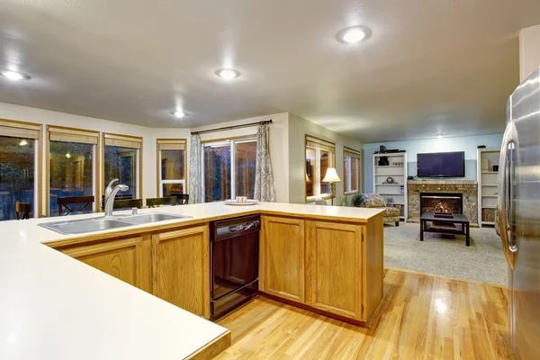 Open floor plan kitchen interior with brown cabinets and hardwood floor