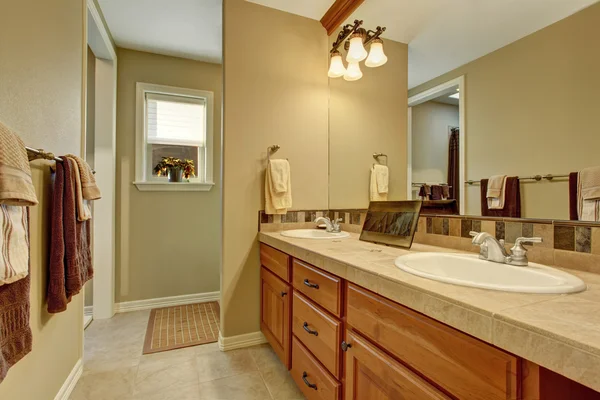 Intérieur salle de bain avec armoires en bois et grand miroir — Photo