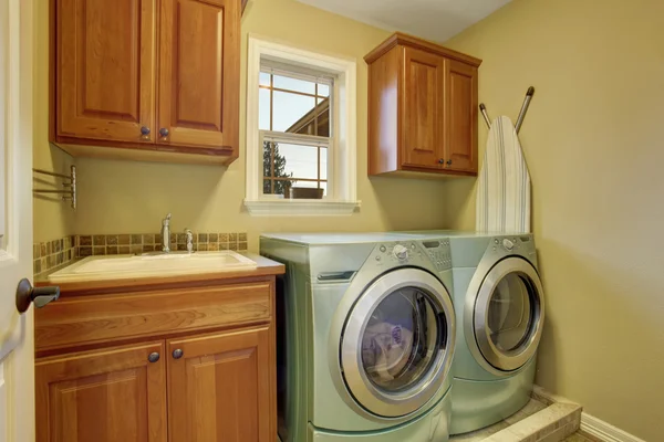 Laundry room with washer and dryer. Wooden cabinets and sink — Stock Photo, Image