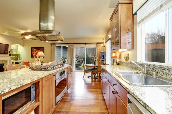 Sala de cozinha brilhante com piso de madeira, armários castanhos claros — Fotografia de Stock