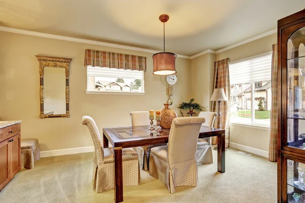 Zona de comedor con paredes de color beige y muebles de madera antiguos — Foto de Stock