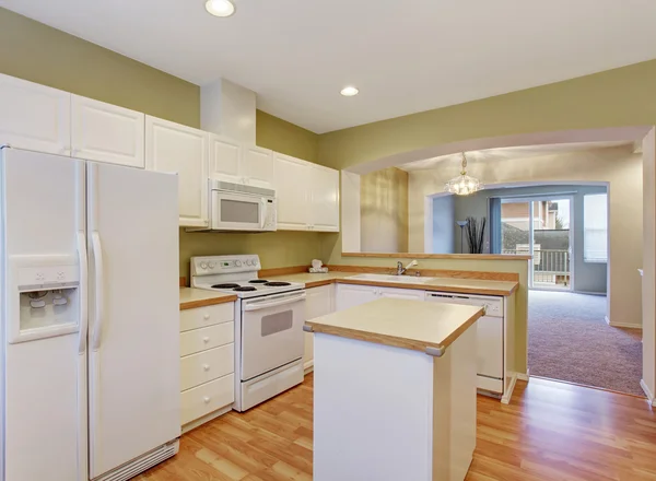 White kitchen cabinets with steel appliances and island, — Stock Photo, Image