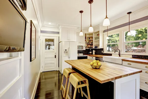 Interior da cozinha em tons brancos com bancada de madeira dura . — Fotografia de Stock