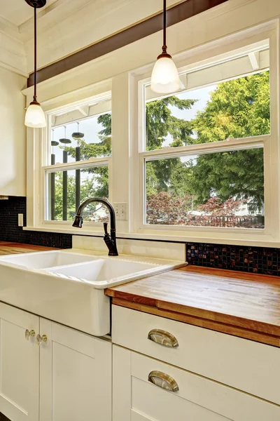 Keuken interieur in witte tinten met hardhout counter top. — Stockfoto
