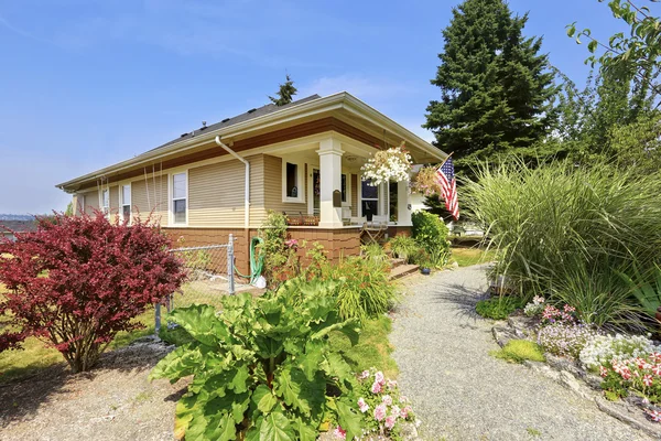 View of American craftsman house with lots of greenery in the front.