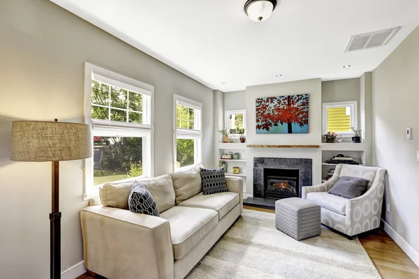 Pequena, mas agradável e acolhedora sala de estar com lareira e sofá . — Fotografia de Stock