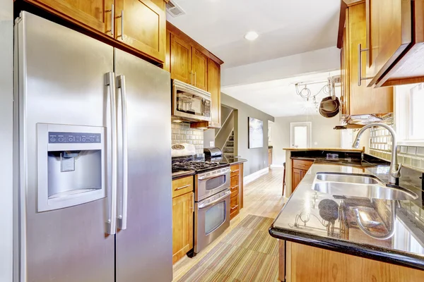 Estrecha cocina interior con armarios y electrodomésticos de acero . — Foto de Stock