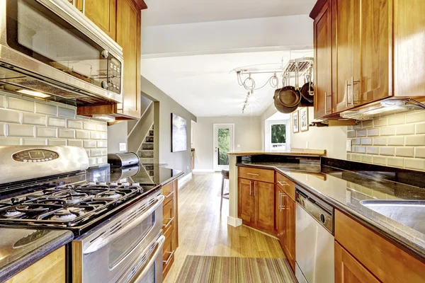 Estrecha cocina interior con armarios y electrodomésticos de acero . — Foto de Stock