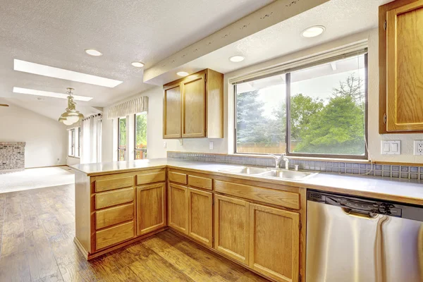 Cocina con armarios de madera dorada y suelo de madera . —  Fotos de Stock