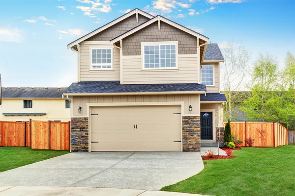 American house exterior with beige trim, garage with concrete driveway — Stock Photo, Image