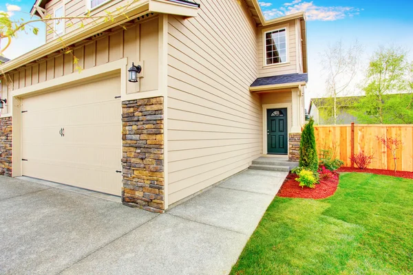 American house exterior with beige trim, garage with concrete driveway — Stock Photo, Image