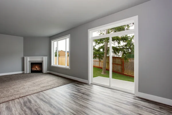 Grey living room interior.  Windows and Glass doors overlooking the back yard. — Stock Photo, Image