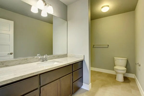 Intérieur salle de bain lumineuse avec sol carrelage et meuble lavabo avec grand miroir . — Photo