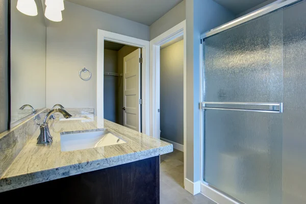 Bright bathroom interior with glass shower and tile floor. — Stock Photo, Image