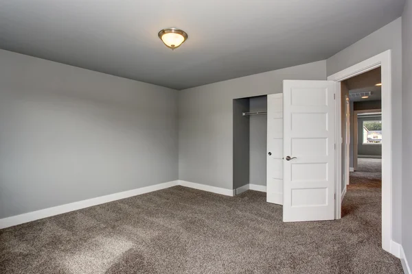 Small basement room interior with grey walls and white trim. — Stock Photo, Image