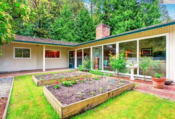 Beautiful front yard landscape with vegetable garden and red tile walkway. — Stock Photo, Image