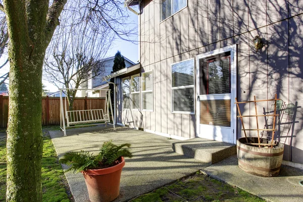 Blick auf den Hinterhof mit Patio und weißer Holzschaukel. — Stockfoto