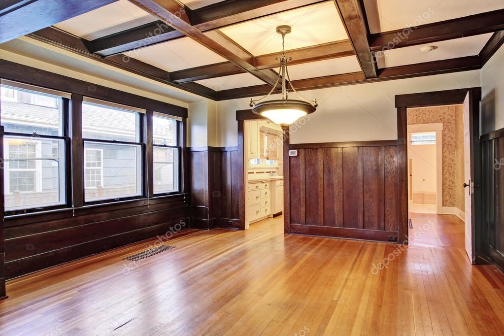 Empty Room With Wood Paneled Walls And Coffered Ceiling