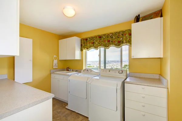 Gammal tvättstuga med vita skåp och gula väggar. — Stockfoto