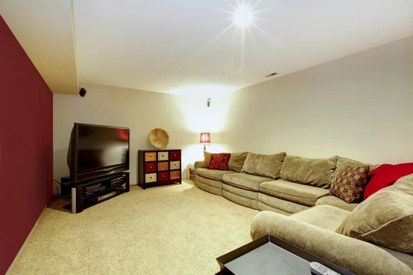 Salón interior con sofá beige, suelo de moqueta y pared roja . — Foto de Stock