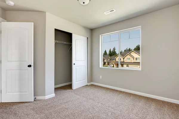 Pequeno quarto vazio com janela e piso de carpete . — Fotografia de Stock