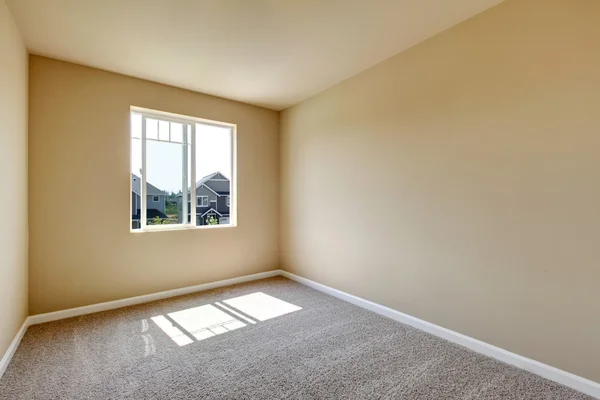 Bright empty room with one window and beige walls — Stock Photo, Image