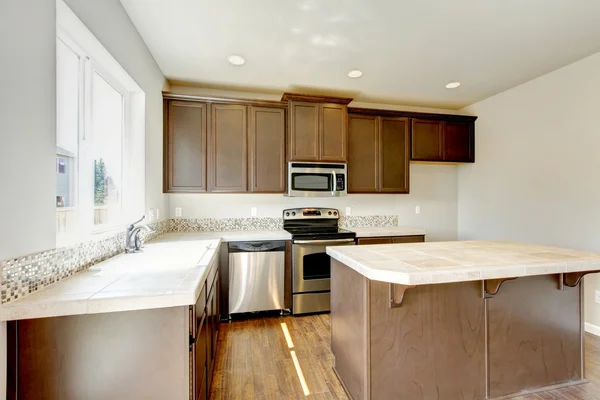 Liten men praktiskt kök med brunt skåp och kakel marmor toppar. — Stockfoto