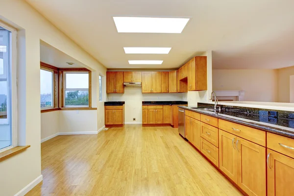 Spacious kitchen room with cabinets and black granite tops. — Stock Photo, Image