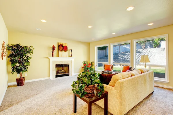 Bright living room with fireplace and beige sofa. — Stock Photo, Image