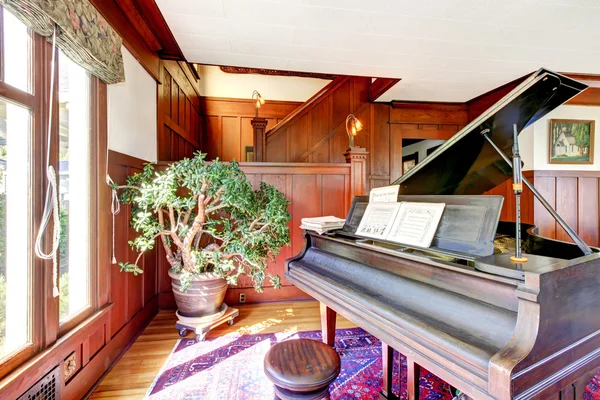 Bright living room with wooden panel trim walls and grand piano — Stock Photo, Image