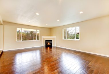 Cilalı parke zemin ve köşe şömine ile boş oturma odası.