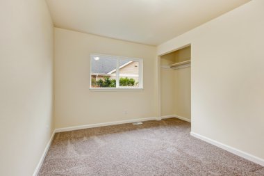 Dolap ile sıcak kremsi tonları küçük boş oda