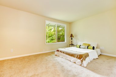 Küçük yatak ve lamba ile boş parlak yatak odası.