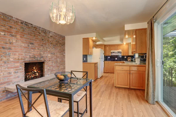 Nice dining room with hardwood floor and brick tile fireplace. — Stock Photo, Image