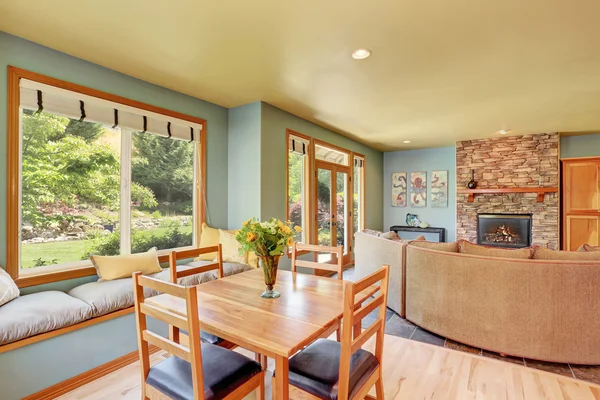 Zona de comedor con mesa de madera y acogedor lugar de estar . — Foto de Stock