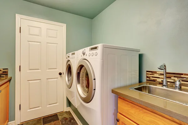 Lavandaria de hortelã com eletrodomésticos brancos e pia — Fotografia de Stock
