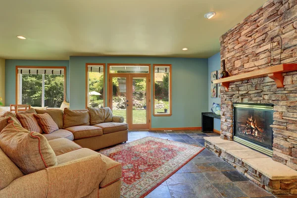 青い壁と石のタイル暖炉が備まる居心地の良いリビングルーム. — ストック写真
