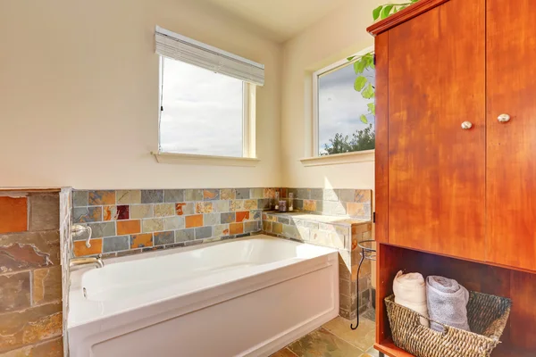 View of bathtub with natural stone tile trim — Stock Photo, Image