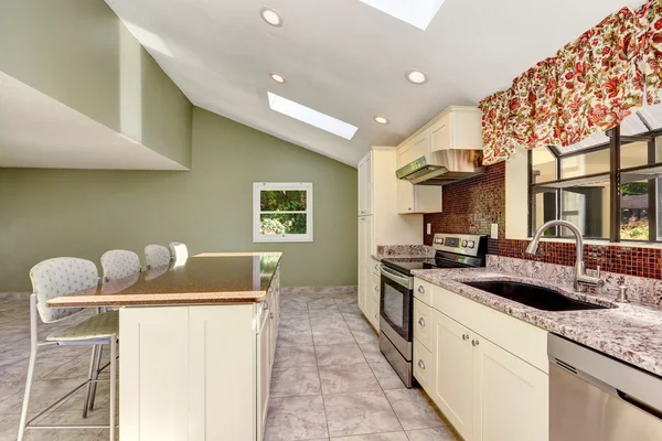 Bright sunny kitchen with vaulted ceiling and skylights. — Stock Photo, Image