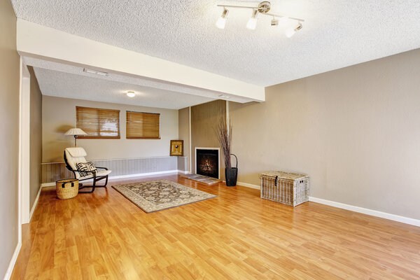 Spacious empty living room with fireplace and chair